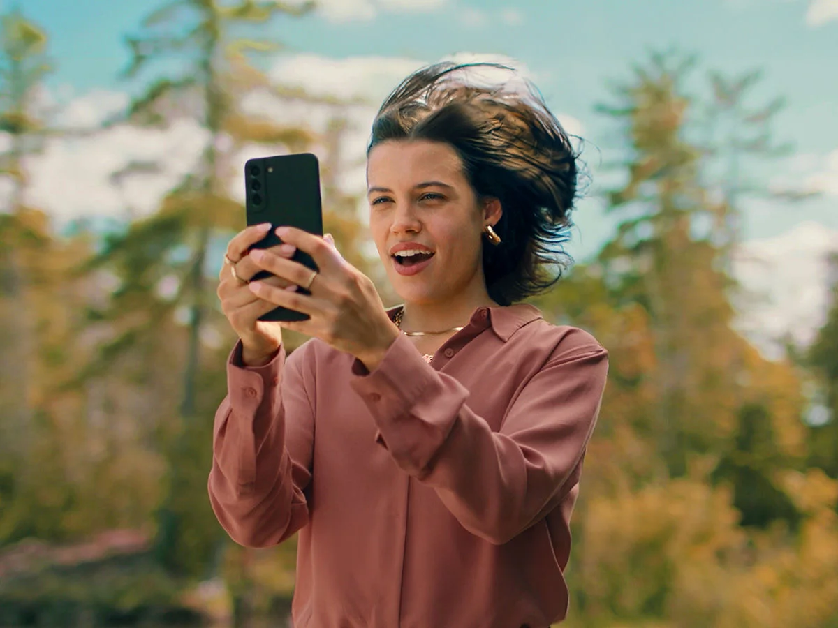 Woman using a mobile phone on Optimum's 5G Network, Unlocking Maximum Value