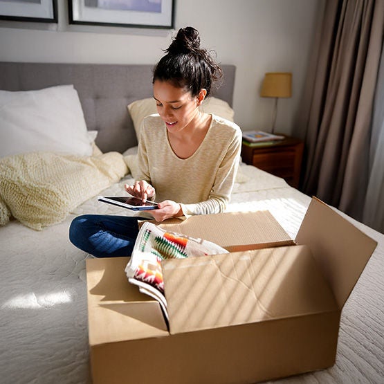 Young lady enjoying Optimum Internet while moving into her new home.