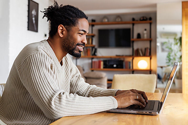 man with gray top using Optimum Wi-Fi to search the Internet